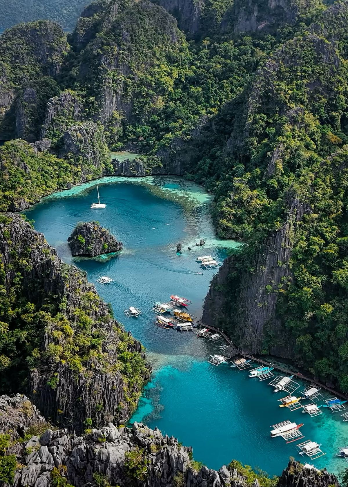 Woman paddling a bamboo raft in Coron